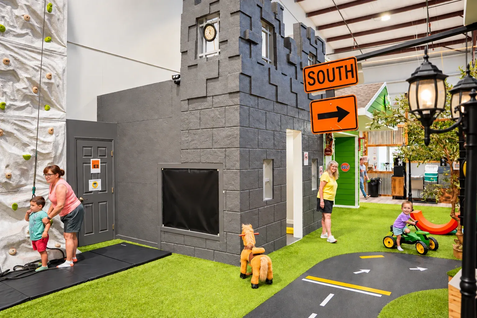 Castle playhouse, miniature roadway and ride-on toys inside Fort Rock.