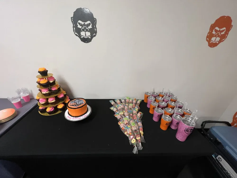 A Fort Rock birthday cake, cupcake tower, candy and branded cups on the party table