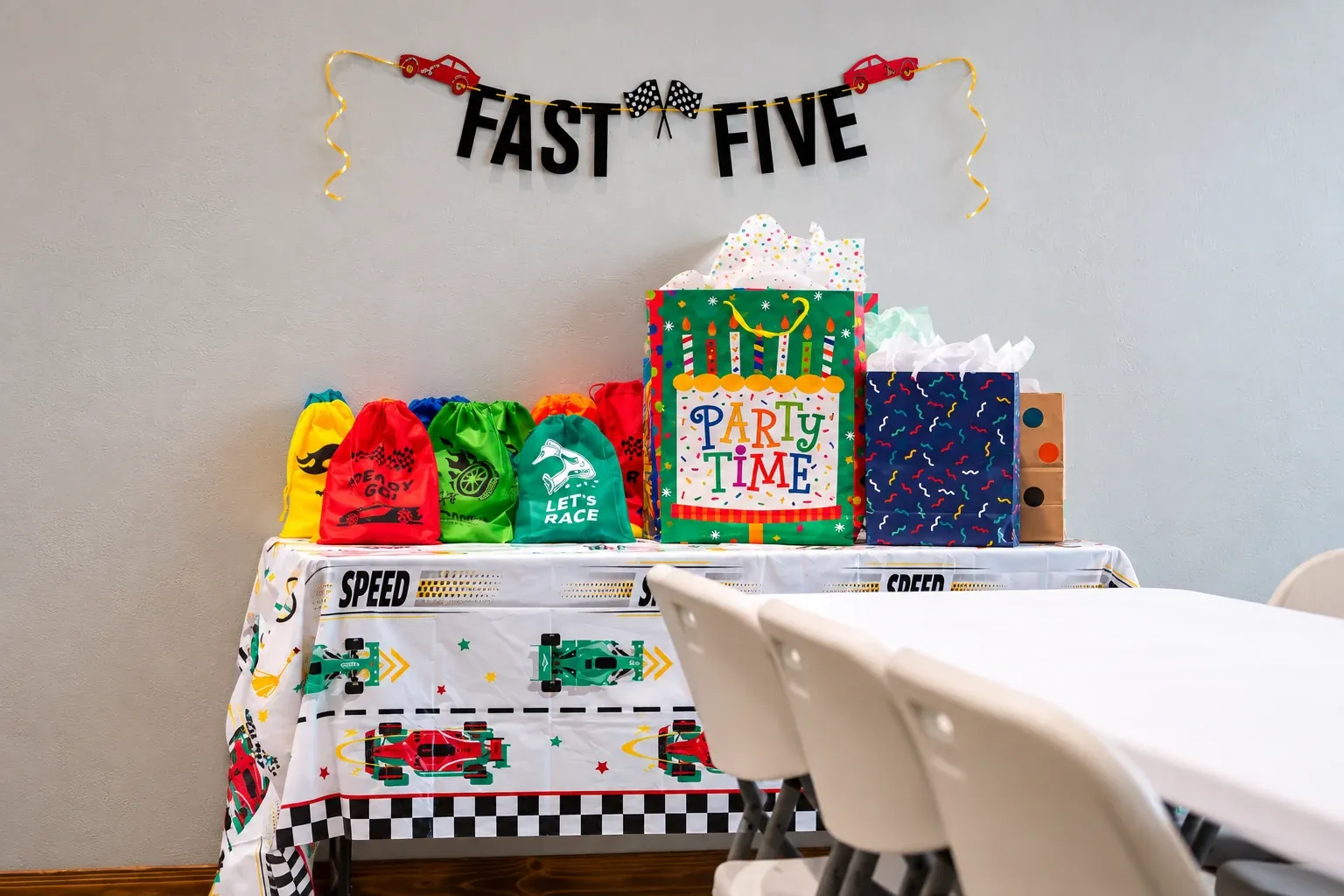 Racing-themed birthday decorations and gift bags on a party table at Fort Rock.