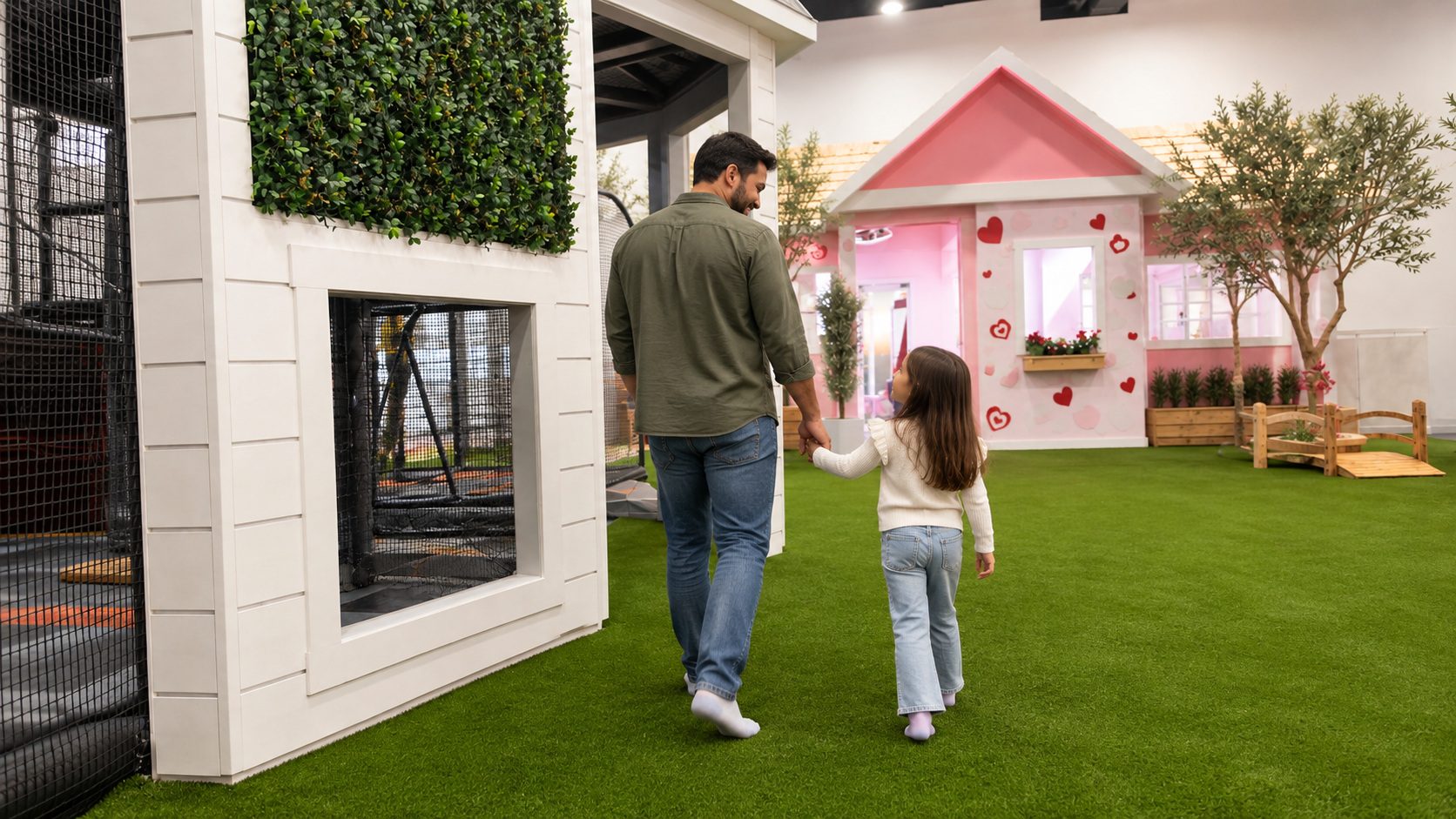 Father and daughter walking through the play village toward the pink heart playhouse